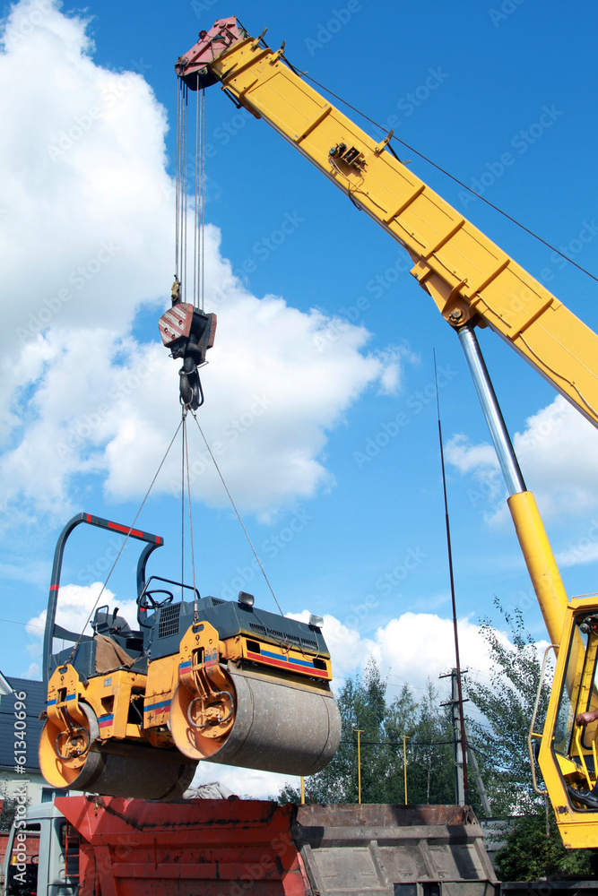 Fototapeta premium Loading compactor on the transportation machine using a crane