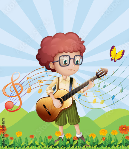 A boy with his guitar at the hills