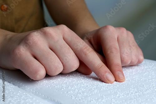 Blind woman read book written in Braille