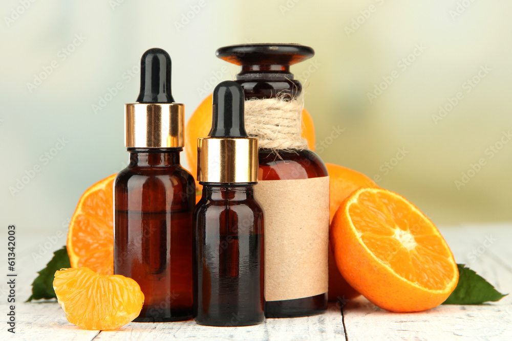 Tangerine essential oil and tangerines on wooden table Tangerine essential oil and tangerines on wooden table