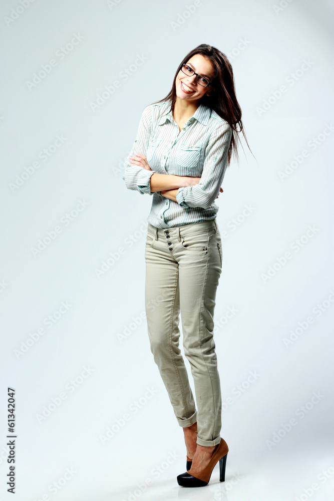 smiling woman with arms folded isolated on gray background smiling woman with arms folded isolated on gray background
