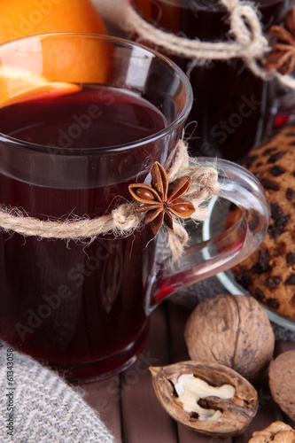 Mulled wine with orange and nuts on table close up