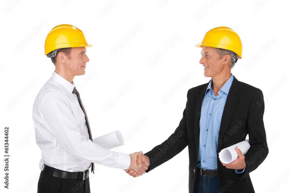 two workers shaking hands and smiling. two workers shaking hands and smiling.