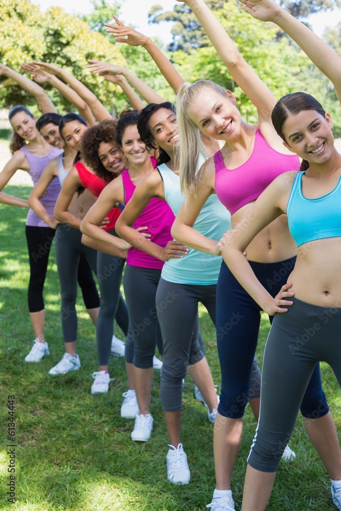Women performing stretching exercise at park Women performing stretching exercise at park
