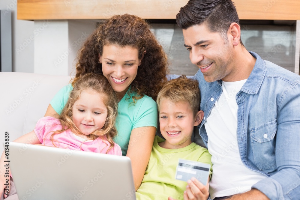 Happy family sitting on sofa using laptop together to shop Happy family sitting on sofa using laptop together to shop