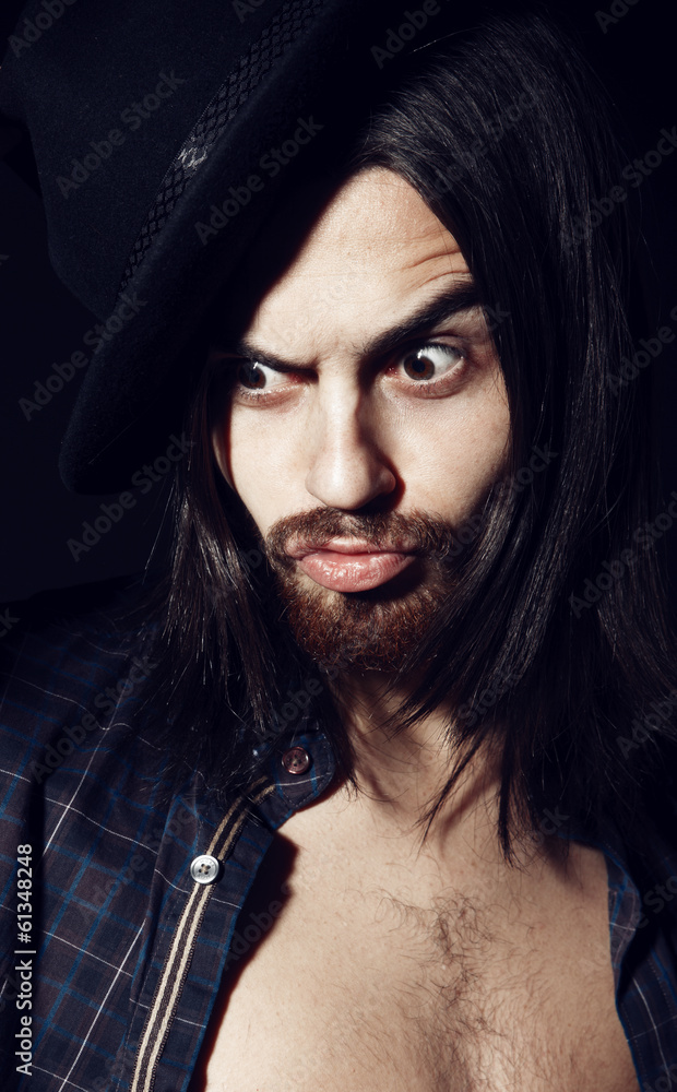 Obraz premium Portrait of a handsome man with a hat in the studio, closeup
