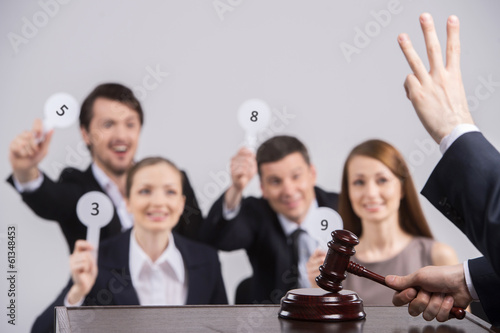 Картината върху платно four people raising cards with number.