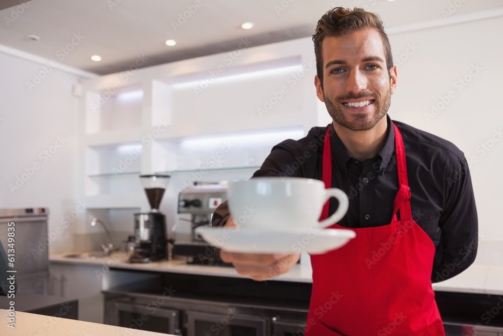 Happy barista offering cup of coffee to camera Happy barista offering cup of coffee to camera