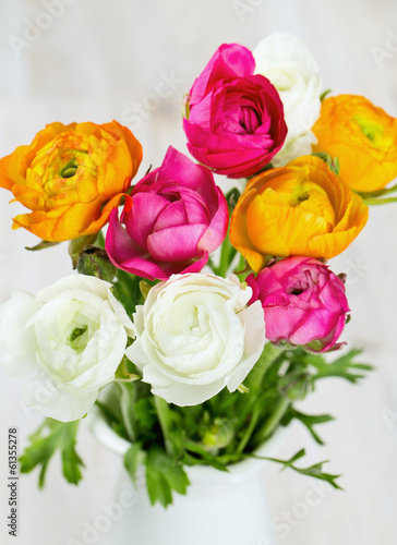 bouquet of white  pink and orange buttercups on wooden table