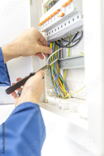 Electrician checking the wiring in a fuse box