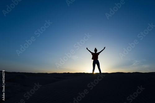 Silhouette de femme debout, soleil couchant