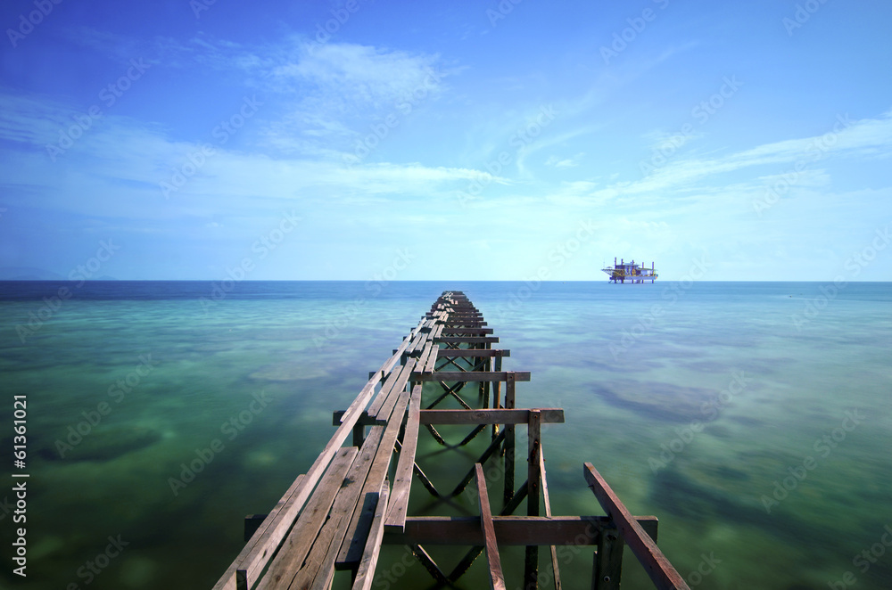 view of old broken jetty during sunny day with coral and green s view of old broken jetty during sunny day with coral and green s