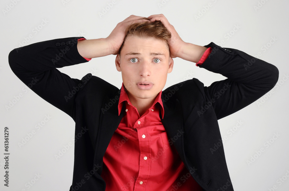Young business man holding his head frowning with worry. Young business man holding his head frowning with worry.