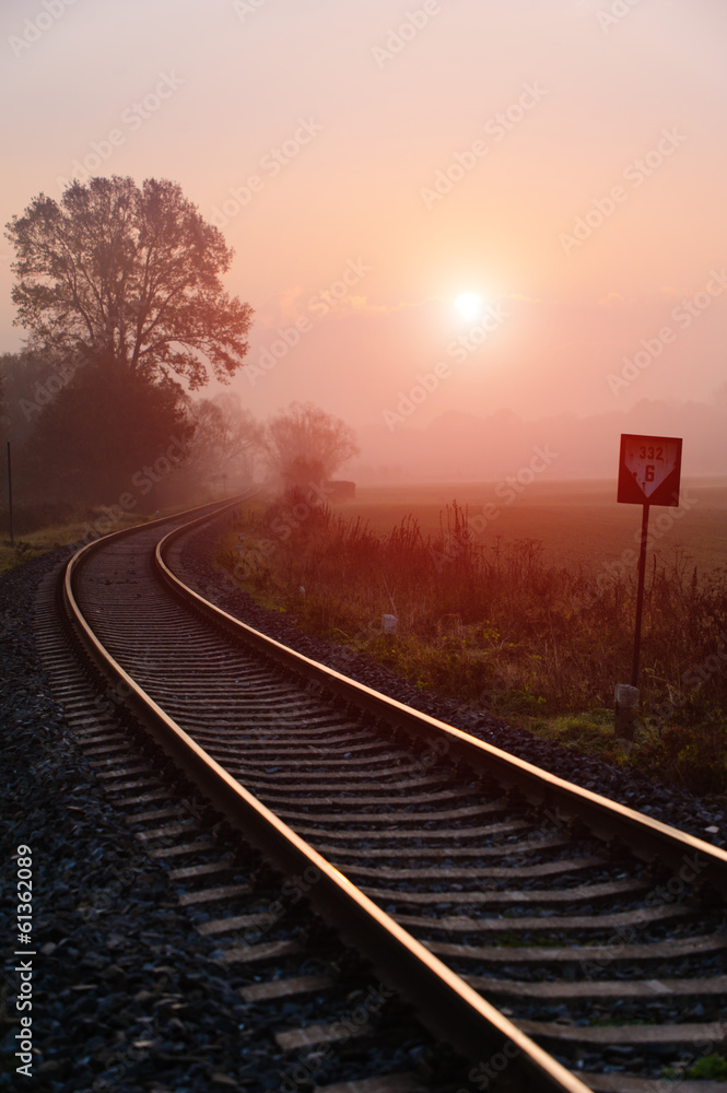 Fototapeta premium Railroad track during autumn foggy morning