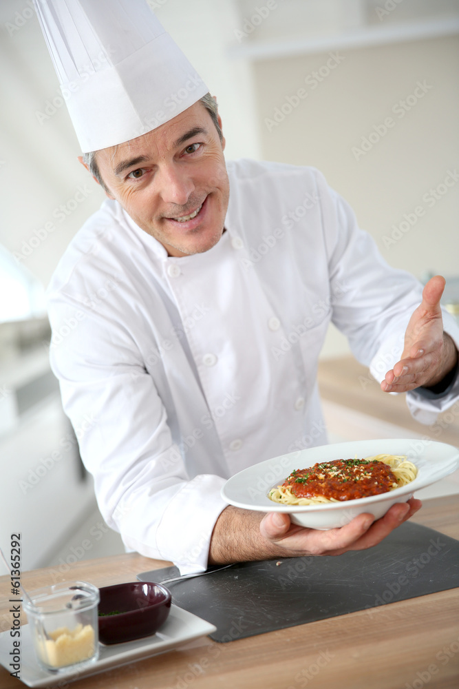 Chef in kitchen presenting italian dish Chef in kitchen presenting italian dish