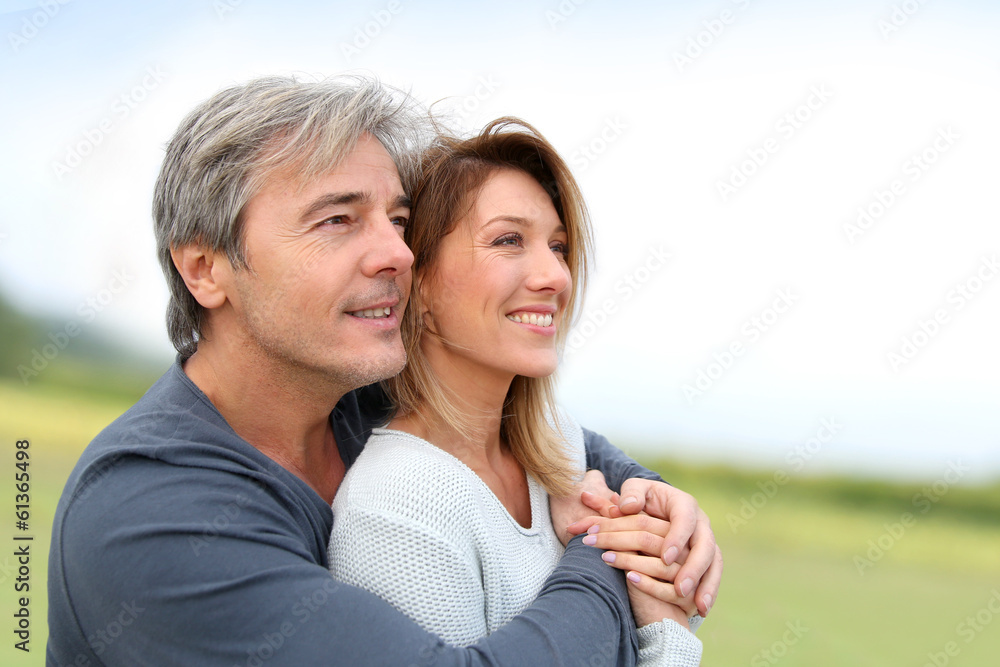Obraz premium Portrait of smiling middle-aged couple in countryside