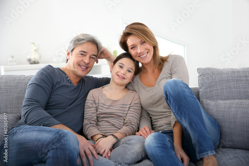 Happy family of three relaxing in sofa
