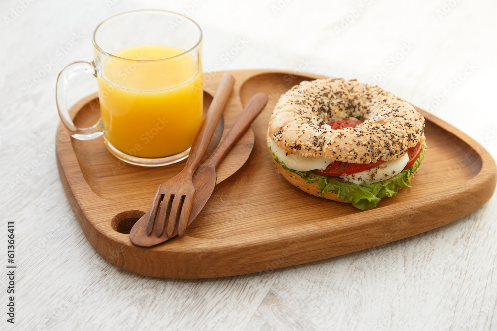 A bun sandwich and juice on a wooden plate A bun sandwich and juice on a wooden plate