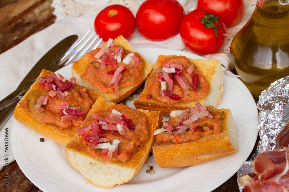 plate of bread with tomatoes and jamon