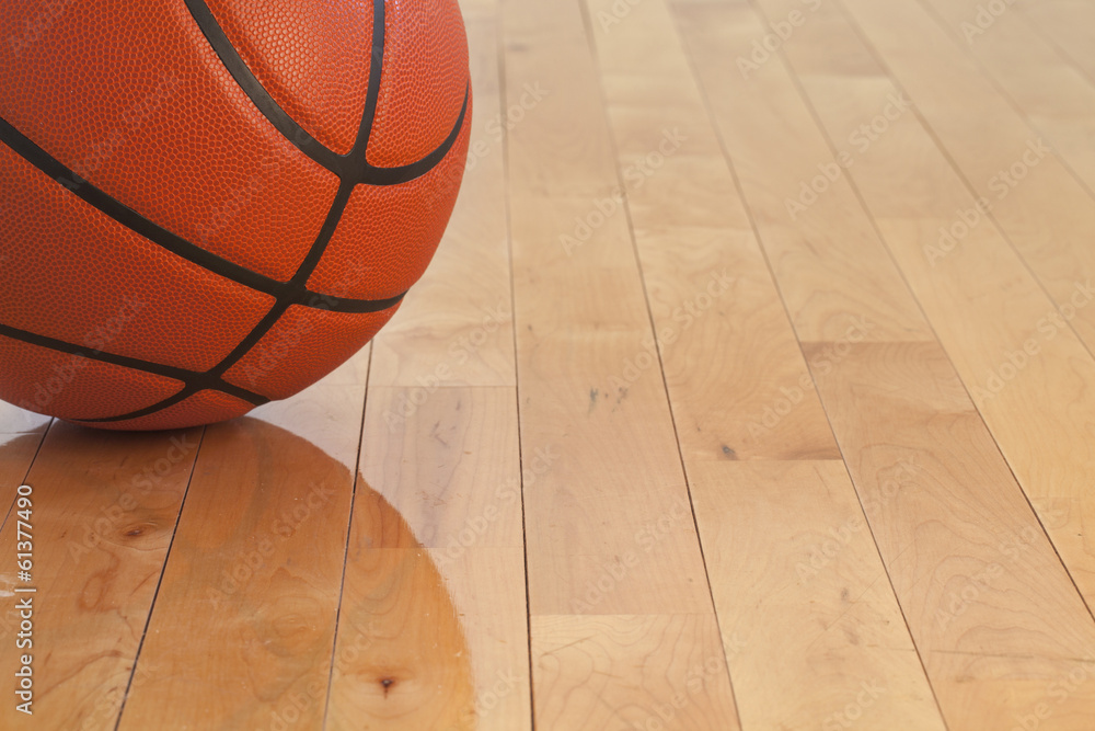 Fototapeta premium Low angle view of basketball on wooden gym floor
