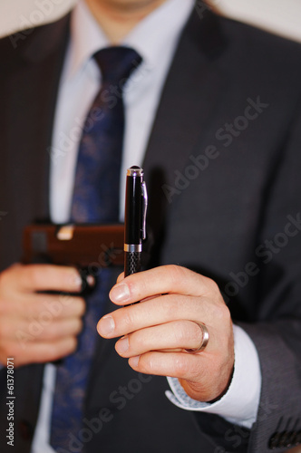 Mann mit Kugelschreiber und Waffe