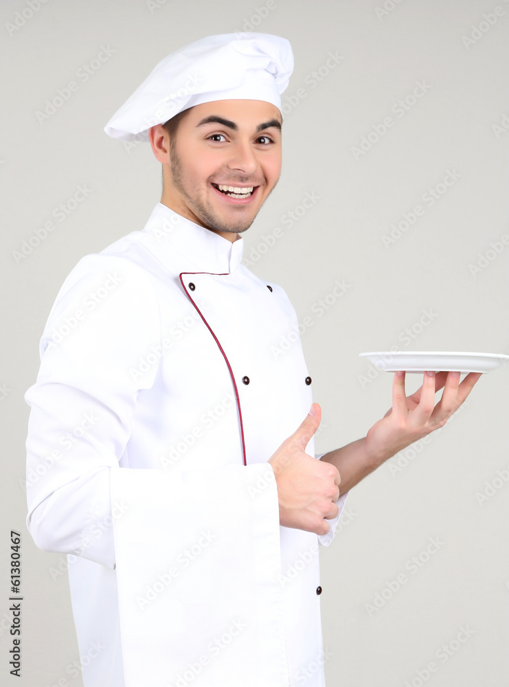 Professional chef in white uniform and hat, on gray background Professional chef in white uniform and hat, on gray background