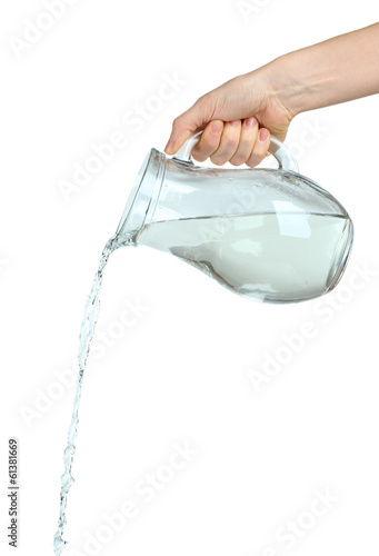 Pouring water from glass pitcher, isolated on white