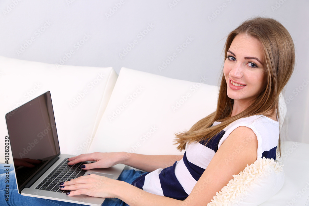 Young woman resting with laptop on sofa at home Young woman resting with laptop on sofa at home
