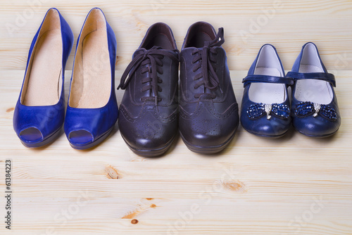 Three pair of shoes isolated on wooden background