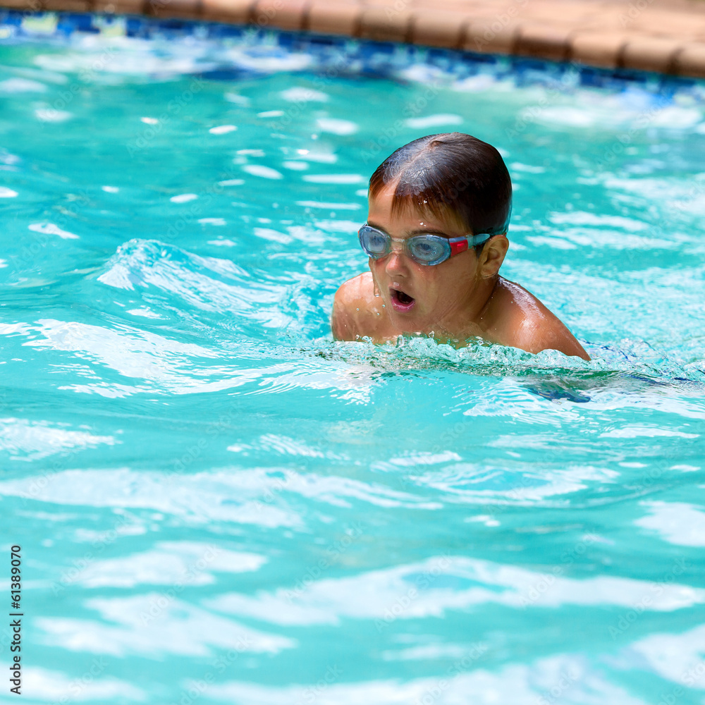 Boy practicing breaststroke in pool.