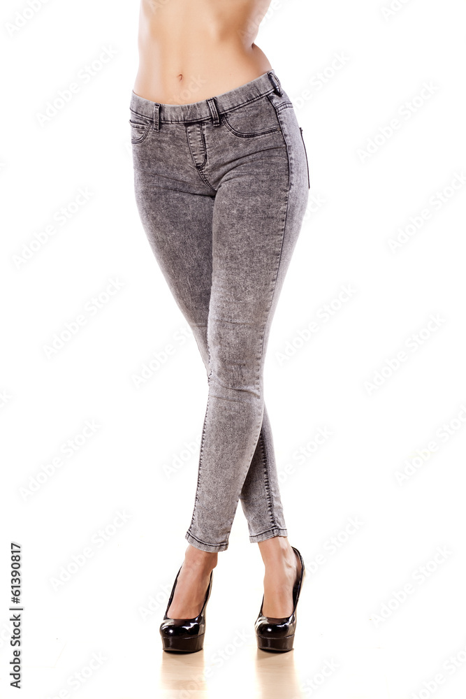 pretty female legs in tight jeans on white background pretty female legs in tight jeans on white background