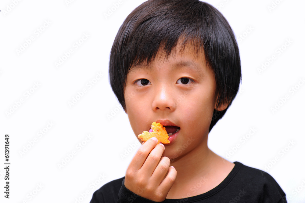 Asian boy eating candy ( isolated on white ) Asian boy eating candy ( isolated on white )