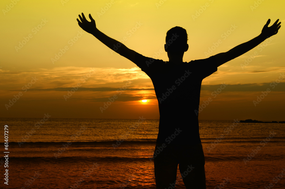 Man welcoming the sun, sunrise on the beach