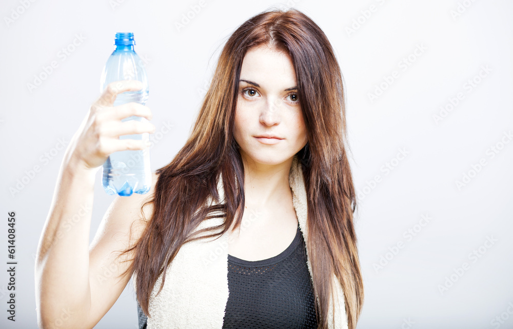 Woman after fitness class proposing a bottle of water Woman after fitness class proposing a bottle of water