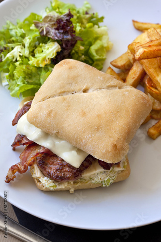 Hamburger avec bacon et steak, frites et salade photo