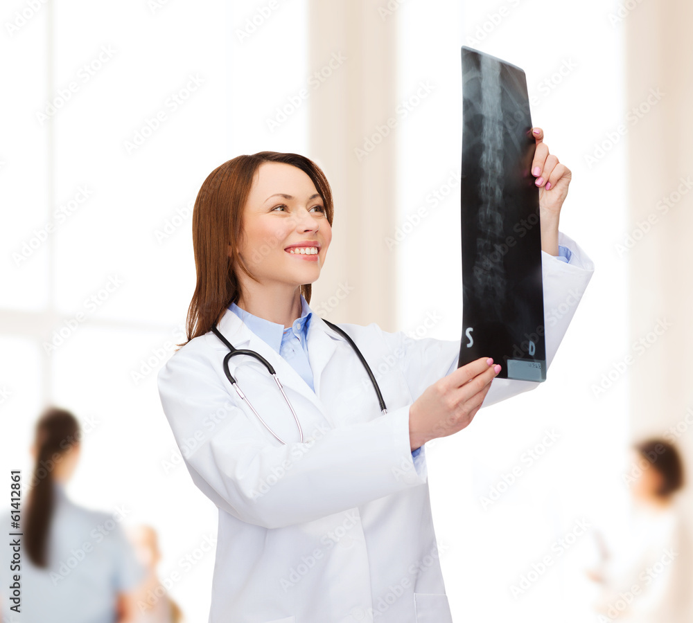 smiling female doctor looking at x-ray smiling female doctor looking at x-ray