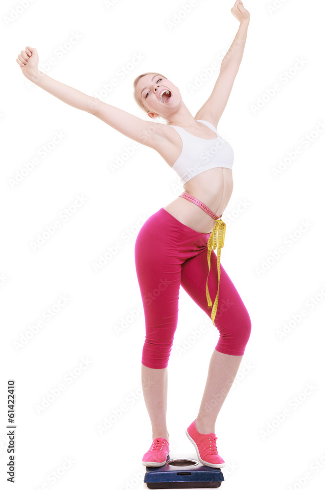 Woman with measure tape on scale celebrating weightloss Woman with measure tape on scale celebrating weightloss