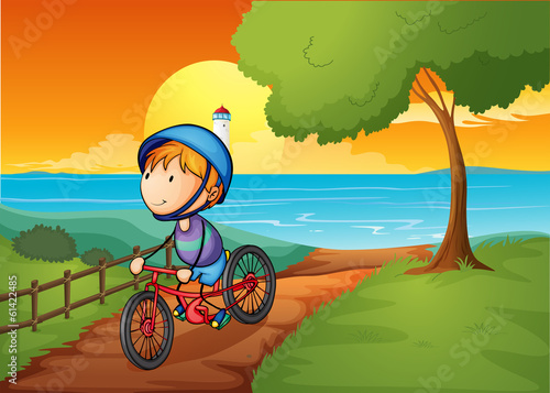 A young boy biking near the river