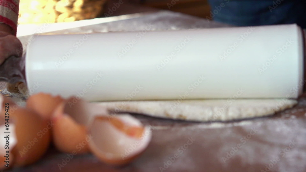 Baker kneading dough with rolling pin on table Baker kneading dough with rolling pin on table