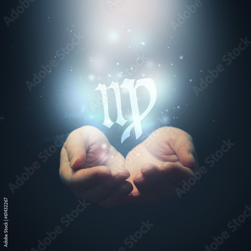 Female hands opening to light and holding zodiac sign for Virgo