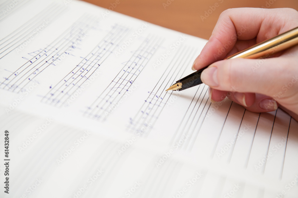 Hand with pen and music sheet Hand with pen and music sheet