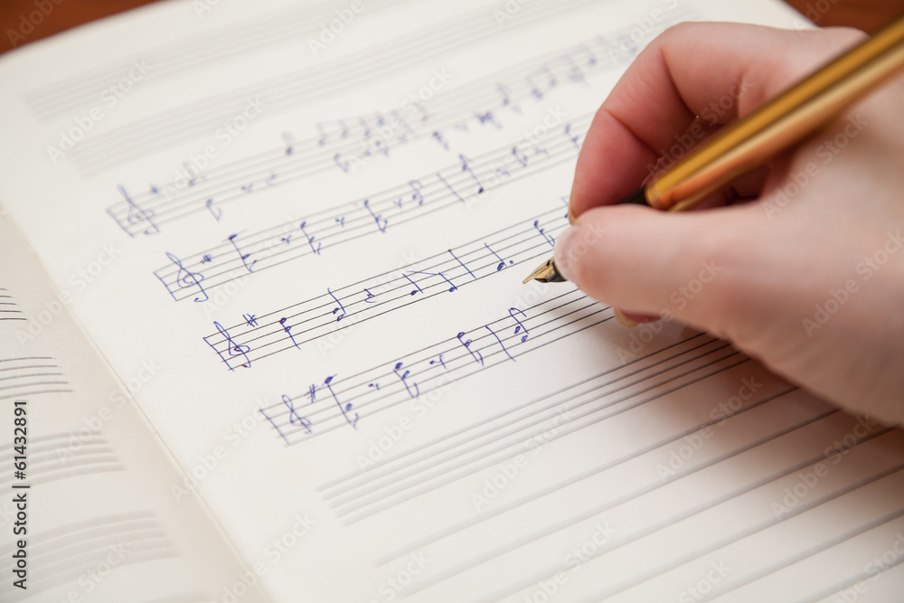 Hand with pen and music sheet Hand with pen and music sheet