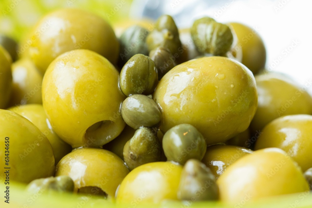 Green olives and capers in bowl, closeup, Italian ingredients Green olives and capers in bowl, closeup, Italian ingredients