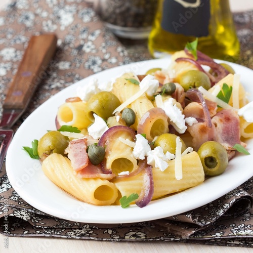 Rigatoni pasta with bacon, green olives, feta cheese, red onion