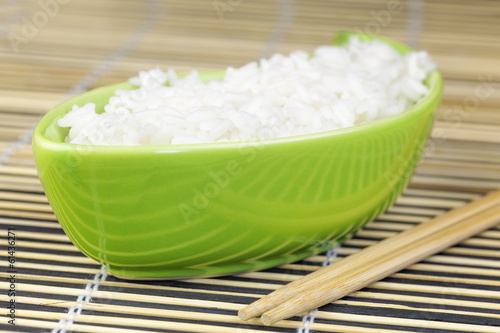 Rice in green clay bowl with wooden chopsticks