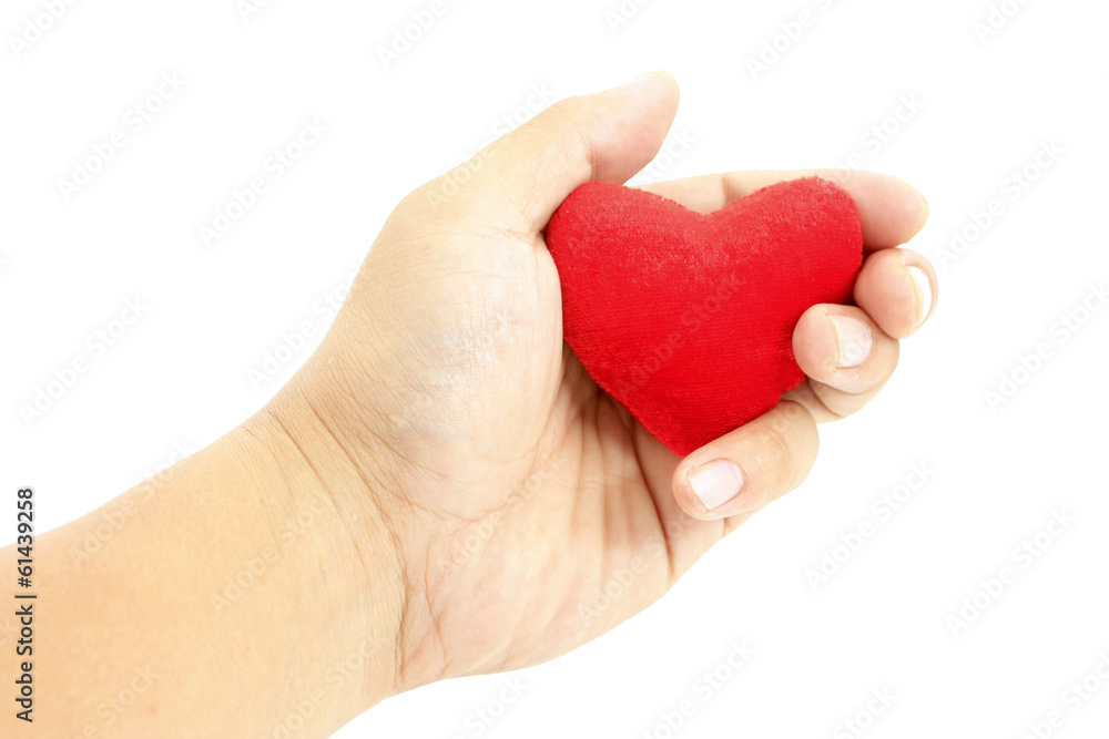 Hand holding small heart shaped pillow isolated on white Hand holding small heart shaped pillow isolated on white