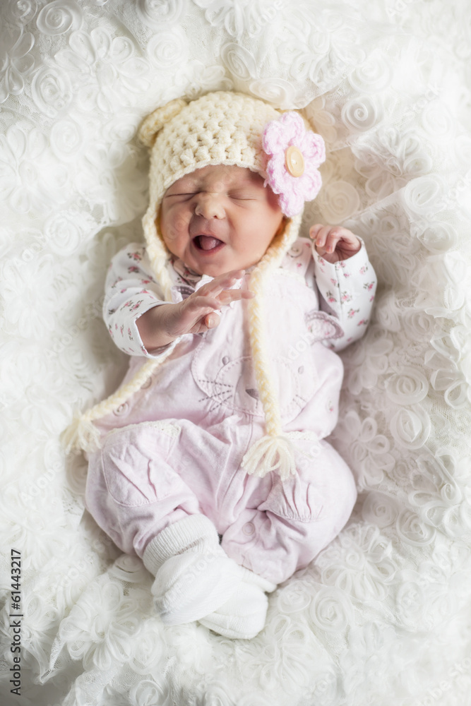 Newborn Mädchen mit süßer Mütze verzieht den Mund Newborn Mädchen mit süßer Mütze verzieht den Mund