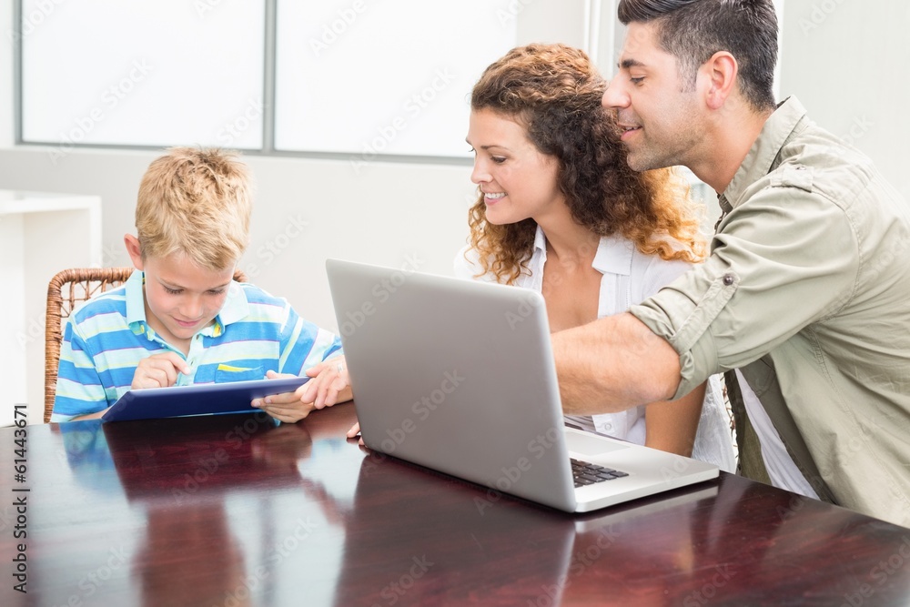 Happy parents showing son how to use tablet pc Happy parents showing son how to use tablet pc