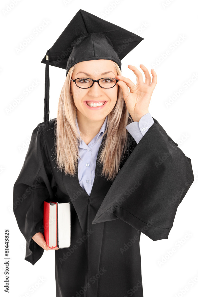 Young female student in graduation gown holding books Young female student in graduation gown holding books