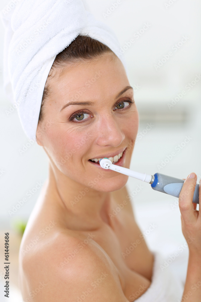 Woman brushing her teeth with electrical toothbrush Woman brushing her teeth with electrical toothbrush